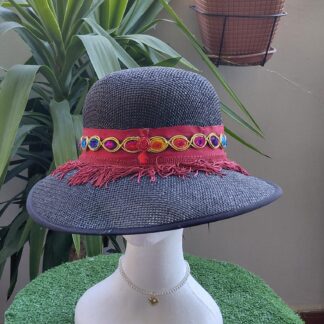 Sombrero negro con flecos vino, grosgrain a tono y tira multicolor gasa y terciopelo, pedrería