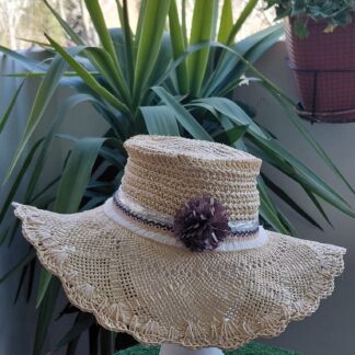 Pamela beige con materiales: flor de tela color topo, tira de flecos de algodón, tira plata metalizada