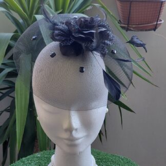 Tocado negro de rejillas con flor de tela negra, pedrería, plumas