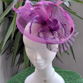 Tocado elegante color buganvilla en tonos morados con materiales: rejillas, plumas autenticas a tono. Alta calidad y diseño. Se entrega con sombrera de calidad.