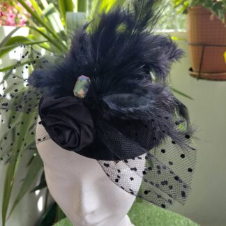 Tocado de pequeño sombrero con rejilla, plumas, pedreria y flor de raso